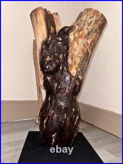 A Women Figure Make Completely Out Of Wood With Gold Foil And A Stained Surface
