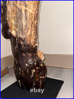 A Women Figure Make Completely Out Of Wood With Gold Foil And A Stained Surface